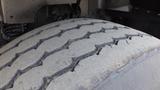 Close-up of a used tire from a 2003 International 5600i showing visible tread wear and grooves on the surface