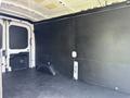 A 2022 Ford Transit van with an empty cargo area featuring a black floor and walls