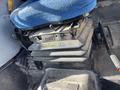 The interior of a 2010 New Holland T4050 tractor featuring a blue upholstered seat with a control lever adjacent to it and a black storage compartment below the seat