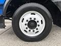 A close-up of a tire and wheel from a 2017 Autocar Xpert featuring a black rubber tire with a white steel wheel and multiple lug nuts