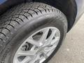 A close-up of a silver wheel and tire on a 2022 Chevrolet Equinox showcasing the tread pattern and emblem