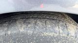 A close-up view of a worn tire from a 2018 Hyundai Sonata showing visible tread wear and dust accumulation