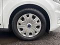 A close-up of a silver wheel from a 2019 Ford Transit Connect showcasing a distinctive design with five elongated spokes and a central blue Ford logo