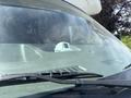 A 2020 Chevrolet Express van is parked with its windshield and dashboard visible featuring a small white device on the dashboard