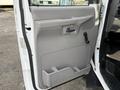 The interior side of a 2002 Ford Econoline van door featuring a gray panel with a door handle and a small pocket for storage