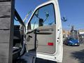 A 2004 Ford F-750 truck's open door showcasing the interior handle and control panel