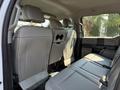 The image shows the spacious back seat area of a 2018 Ford F-550 with light gray upholstery and ample legroom