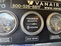 Close-up of a gauge panel featuring a Hobbs hour meter showing 328.10 hours along with receiver pressure and discharge temperature dials
