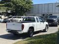A 2011 Chevrolet Colorado pickup truck in white with a regular cab and bed, parked at an angle with black tires and chrome accents