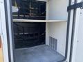 A 2011 Chevrolet Express interior storage area with metal shelving and black straps for securing items