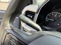 A 2021 Ford F-150 steering wheel with controls for lights and windshield wipers visible on the left side and the speedometer displaying RPM in the dashboard area