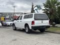 A white 2013 RAM 1500 pickup truck with a cap on the bed parked on a driveway with visible wheels and 4x4 badge