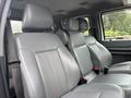 Interior of a 2014 Ford F-550 featuring gray leather seats with headrests and seatbelts visible in a spacious cabin