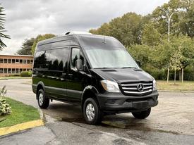 A black 2017 Mercedes-Benz Sprinter van facing the viewer with a high roof and large windows