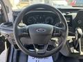 Steering wheel of a 2025 Ford Transit T-350 with control buttons and a key attached, displaying a digital dashboard in the background