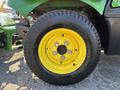 Close-up of a yellow and black tire from a 2021 John Deere 1575 with six bolts visible on the wheel rim