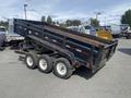 2009 Load 16 foot Dump Trailer with a black body and three axles angled to show its dumping mechanism