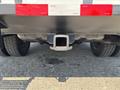 A 2017 Ford F-550 truck's rear hitch and exhaust system are visible with mudflaps and tires partially in view