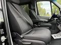 Interior of a 2017 Mercedes-Benz Sprinter showing two black fabric front seats with seat belts and a dashboard visible in the foreground