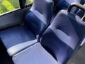 Two blue seats with textured upholstery designed for a van or bus interior