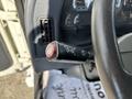 A close-up of a 2012 Autocar Xpert steering column control with indicators and headlight switch