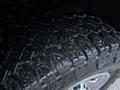 Close-up view of a rugged tire with deep treads designed for off-road performance mounted on a GMC Sierra 3500HD