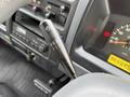 A close-up of the gear shift lever in a 2001 Toyota Dyna showing various gear positions and controls for the vehicle's functions