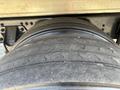 A close-up of a worn tire from a 2022 Freightliner M2 106 showing visible tread wear and a smooth surface