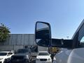 A side mirror of a 2018 RAM 3500 reflecting the sky and nearby vehicles
