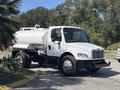 A white 2014 Freightliner M2 106 truck with a large tank on the back and prominent headlights parked at an angle