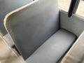 A gray upholstered seat from a 2013 International 4300 bus with a smooth surface and minimal cushioning