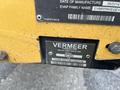 A metal identification plate on a yellow Vermeer Corporation Sweep Stump Cutter displaying the name, date of manufacture, model number, and VIN