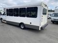 A white 2020 Chevrolet Express shuttle bus with large windows and a gray lower panel is parked with its rear angled toward the viewer