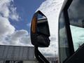 A side mirror of a 2022 Lion Lion6 showing a reflective surface and an integrated amber turn signal light