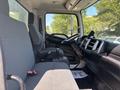 Interior view of a 2020 Hino 338 truck showing the driver's seat steering wheel and dashboard with controls and a gear shift next to the seat