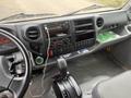 Interior view of a 2019 Hino 155 cab featuring a black dashboard with various controls a radio and a gear shift positioned near the driver's seat
