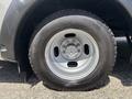 Close-up of a silver wheel with a distinctive rim pattern mounted on a black tire on a 2020 Chevrolet Express