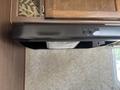 A black range hood with controls positioned above a wooden cabinet in a RV interior