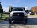 A front view of a white 2015 RAM 4500 truck with a black grill and a flatbed attachment