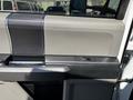 Interior door panel of a 2019 Ford F-550 featuring a black and gray design with a chrome handle and a window control panel