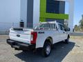 A white 2017 Ford F-250 Super Duty pickup truck with a metal bed rack and 4x4 badge visible on the rear door
