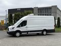 A white 2017 Ford Transit van with a high roof and rear cargo area, parked with its side facing the viewer