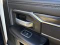 Close-up view of the interior door handle and window control of a 2023 RAM 3500 with a textured black finish and metallic accents