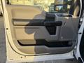 The image shows the interior door panel of a 2018 Ford F-350 SD featuring a grey armrest and black handle with controls for windows and locks