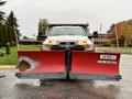 A 2012 Dodge Ram 5500 equipped with a large red snow plow attached to the front with the label Western Contractor Grade visible on the plow