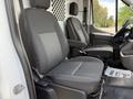 Two black upholstered seats inside a 2021 Ford Transit van with a patterned center section on one seat and a plain design on the other