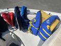 A 2013 Larson 238 boat with various colorful life jackets including red blue and yellow placed on the seating area