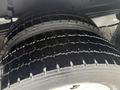 Close-up of a tire from a 2018 Ford E-450 showing tread patterns and a wet surface
