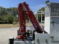 A red hydraulic crane mounted on the back of a 2013 Ford F-550 truck with control panel and warning labels visible