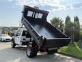 A 2022 Ford F-550 with a raised dump bed displaying the vehicle's open cargo area and heavy-duty construction